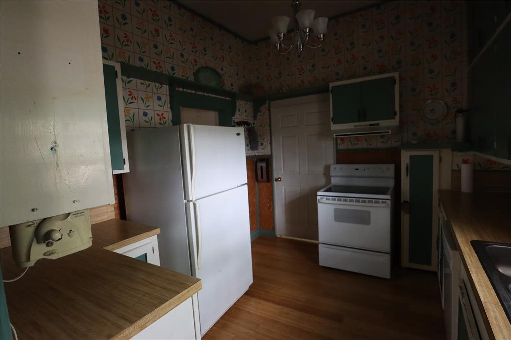 431 Walnut Street Ranger, TX 76470 - Photo 24 of 37 a kitchen with a refrigerator and a stove top oven