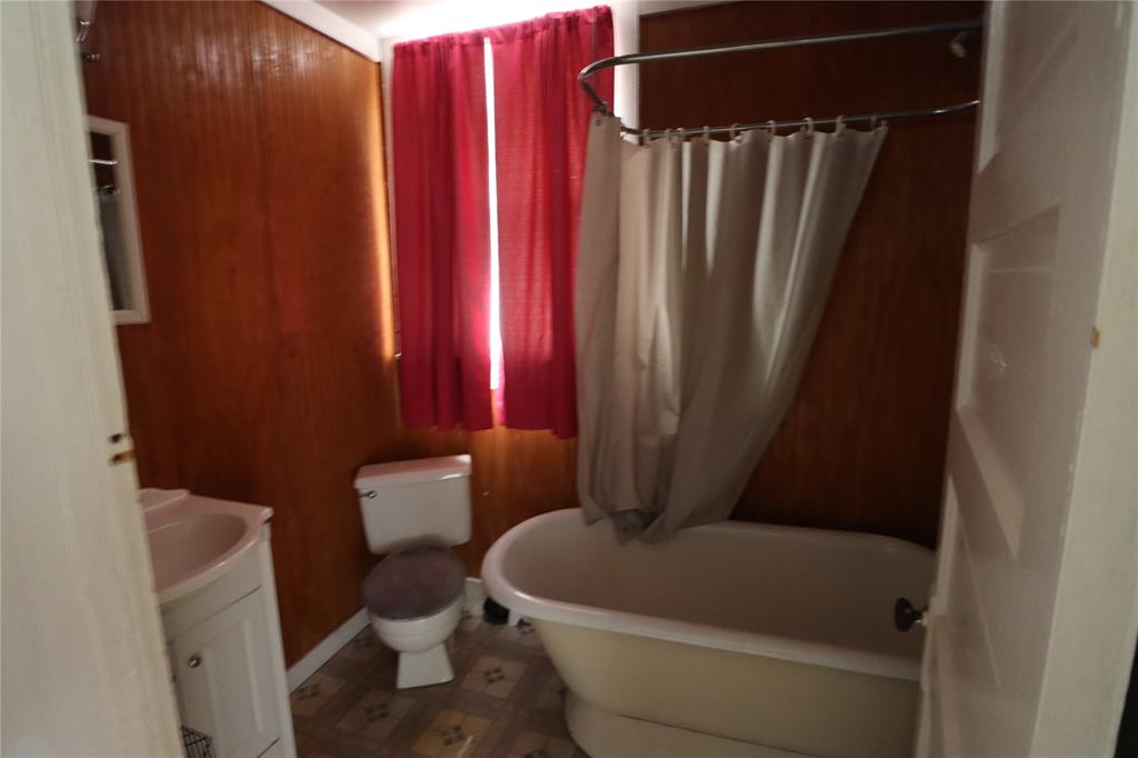 431 Walnut Street Ranger, TX 76470 - Photo 27 of 37 a bathroom with a toilet and a shower curtain
