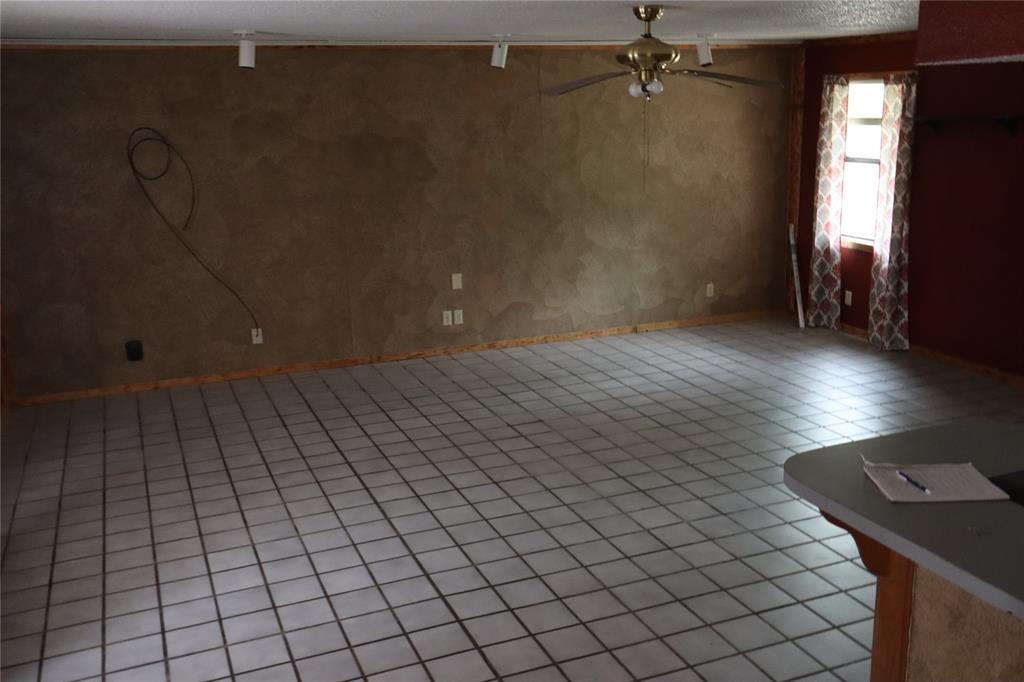 431 Walnut Street Ranger, TX 76470 - Photo 8 of 37 an empty room with wooden floor and windows