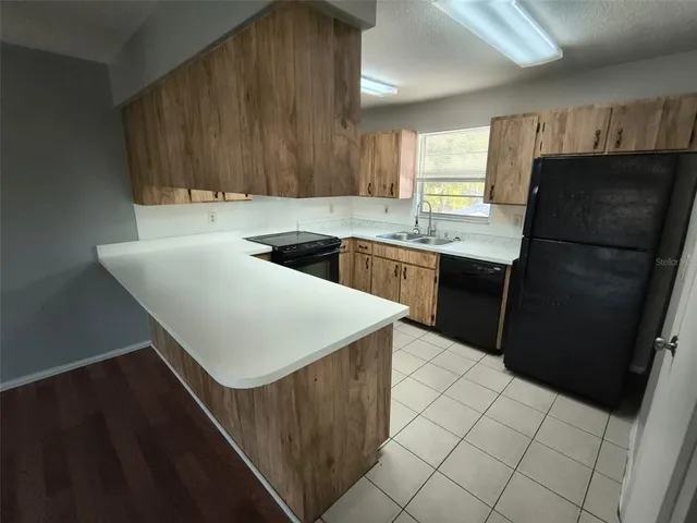 a kitchen with granite countertop a refrigerator and a stove top oven
