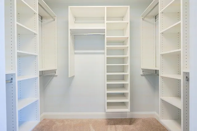 a view of walk in closet with empty racks