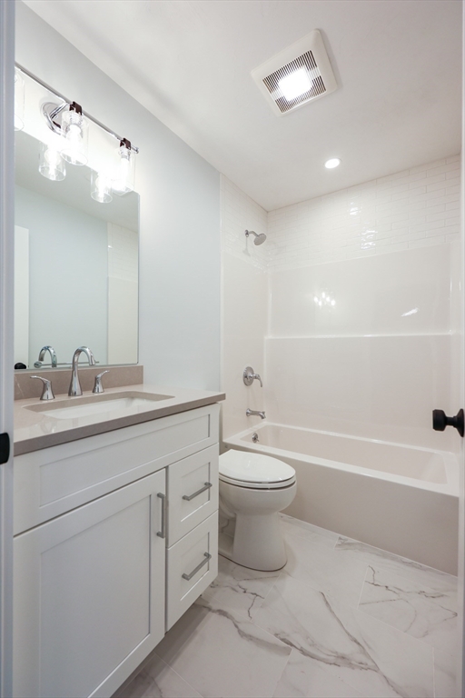58 Baltic Street, Unit 58 Attleboro, MA 02703 - Photo 29 of 34 a bathroom with a toilet a sink a mirror a bathtub and vanity