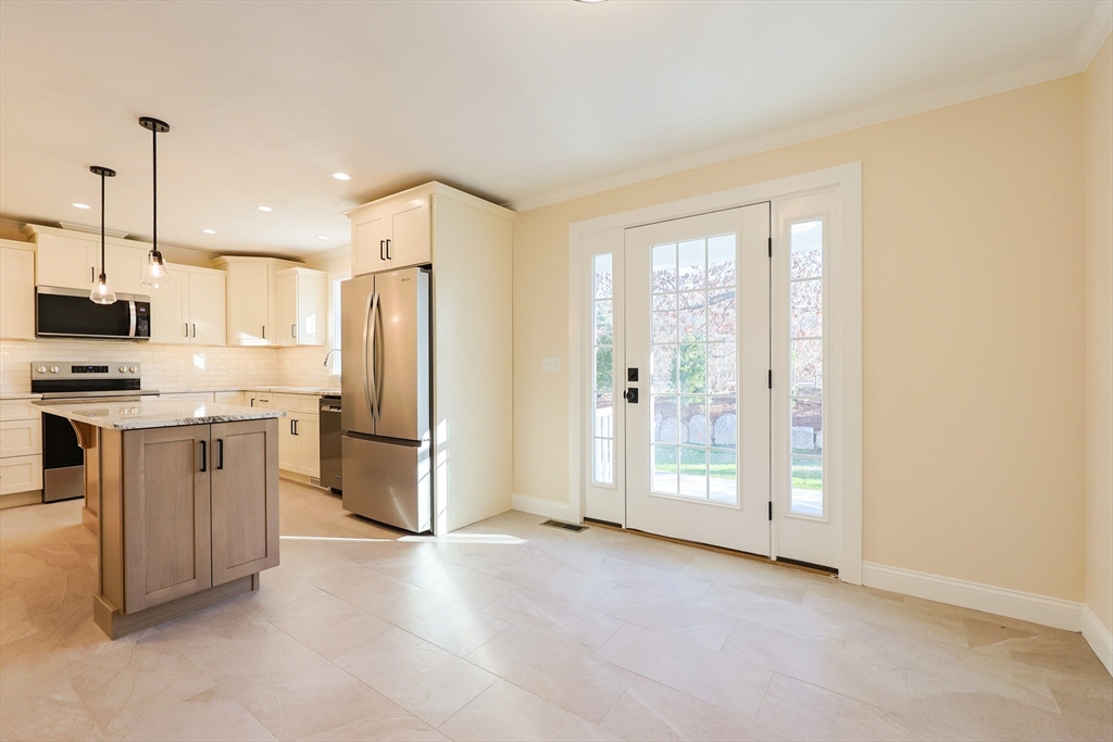 58 Baltic Street, Unit 58 Attleboro, MA 02703 - Photo 7 of 34 a kitchen with stainless steel appliances a refrigerator and a stove top oven