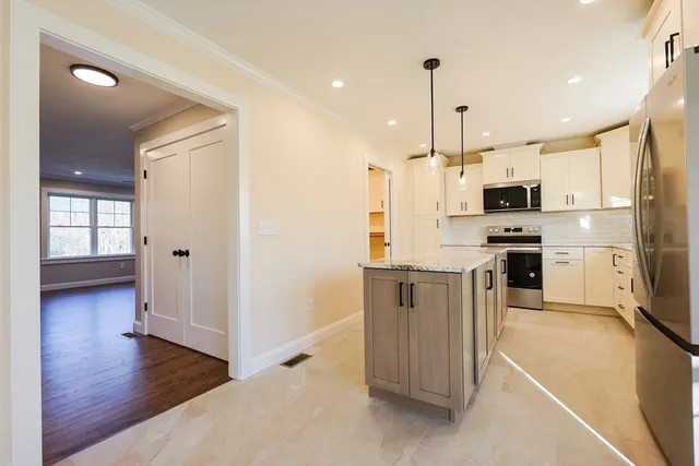 a kitchen with stainless steel appliances granite countertop a refrigerator and a stove top oven