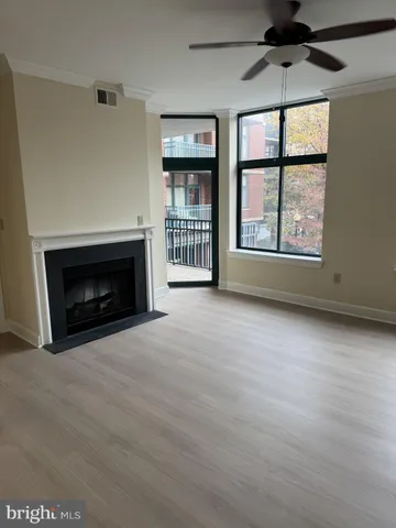 an empty room with windows and fireplace