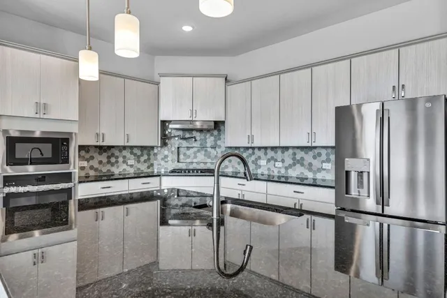 a kitchen with white cabinets and stainless steel appliances
