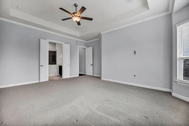 an empty room with a ceiling fan and window