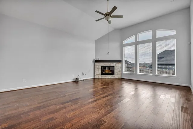 a view of empty room with wooden floor and fireplace