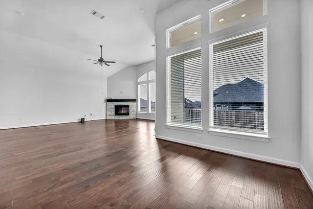 a view of a livingroom with wooden floor a fireplace and window
