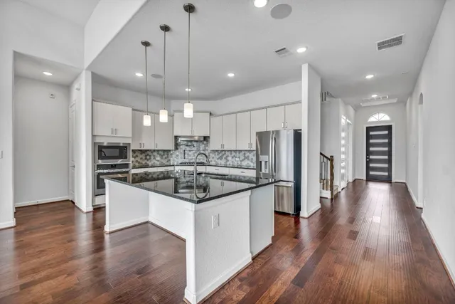 a large kitchen with stainless steel appliances kitchen island a large counter top and a sink