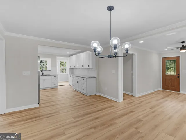 a view of a chandelier in big room and empty room