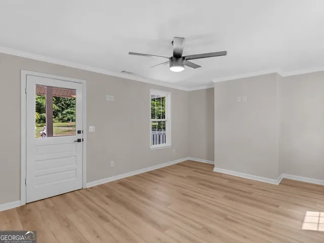 a view of a room with a ceiling fan window and a ceiling fan