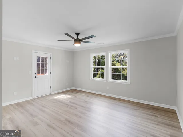a view of a big room with wooden floor and windows