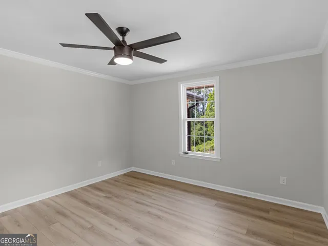 a view of a big room with wooden floor and windows