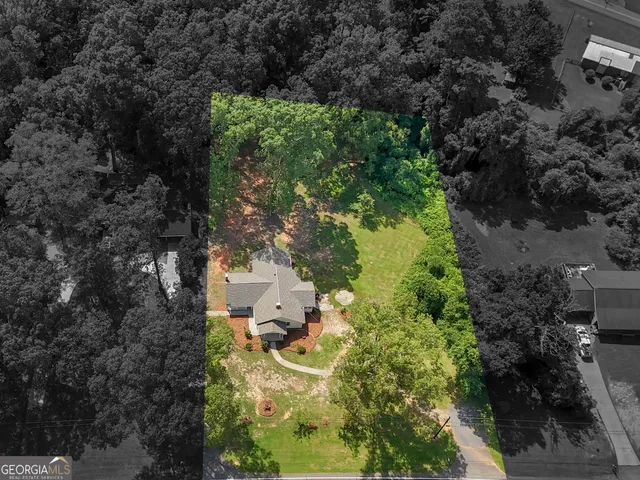 an aerial view of a house with a yard and garden in back