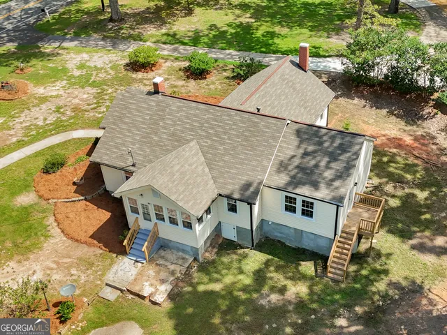 a view of a house with a big yard and large tree
