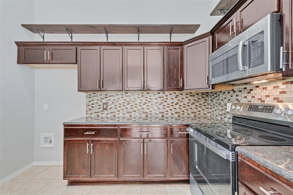 903 Ragland Drive Cedar Hill, TX 75104 - Photo 19 of 33 a kitchen with granite countertop a sink cabinets and stainless steel appliances