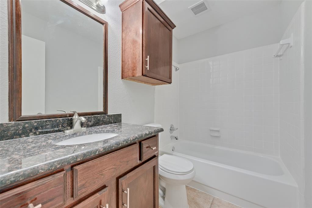 903 Ragland Drive Cedar Hill, TX 75104 - Photo 23 of 33 a bathroom with a granite countertop sink a toilet and bathtub