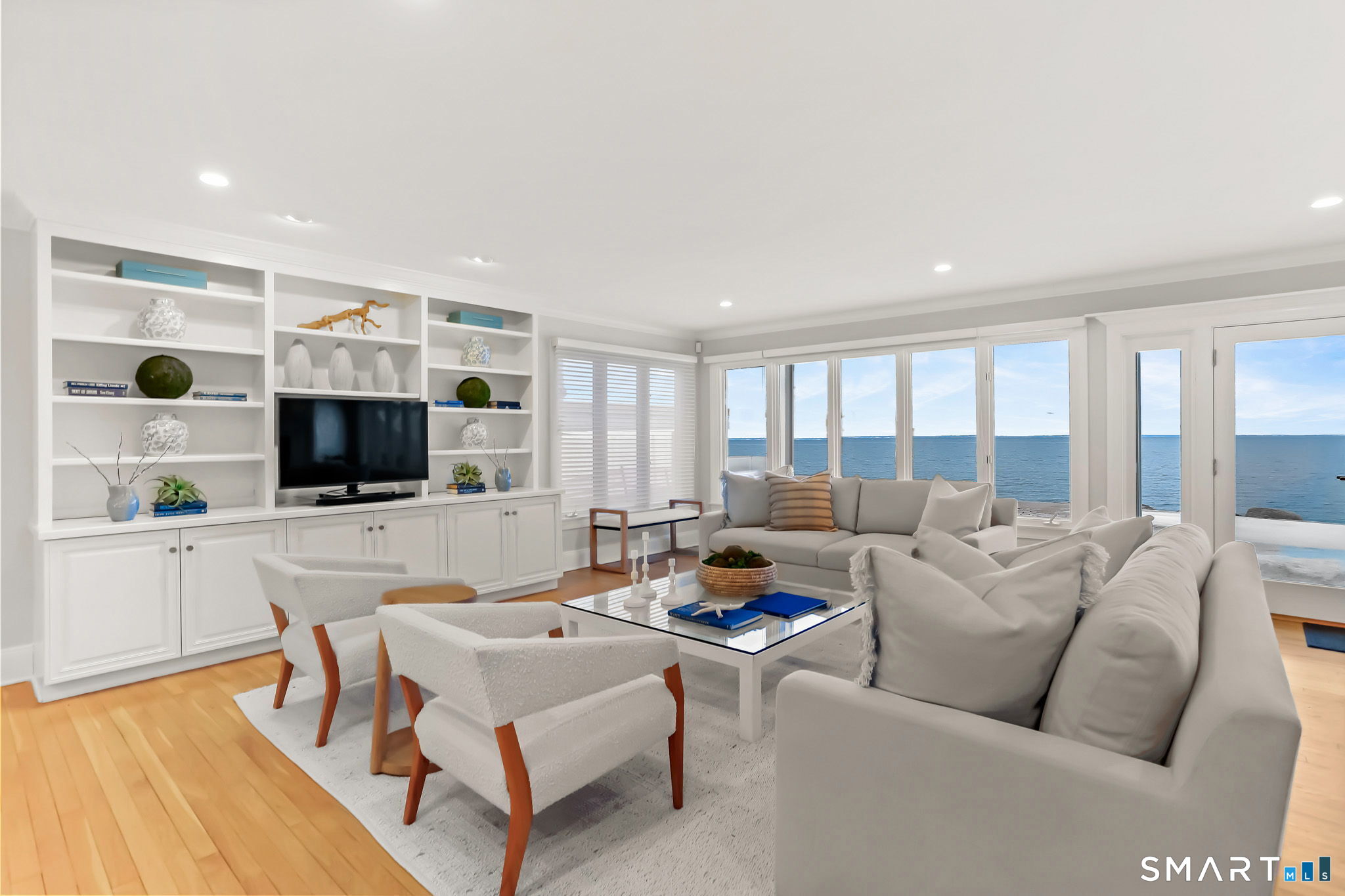 1149 Fairfield Beach Road Fairfield, CT 06824 - Photo 11 of 40 a living room with furniture a flat screen tv and a floor to ceiling window