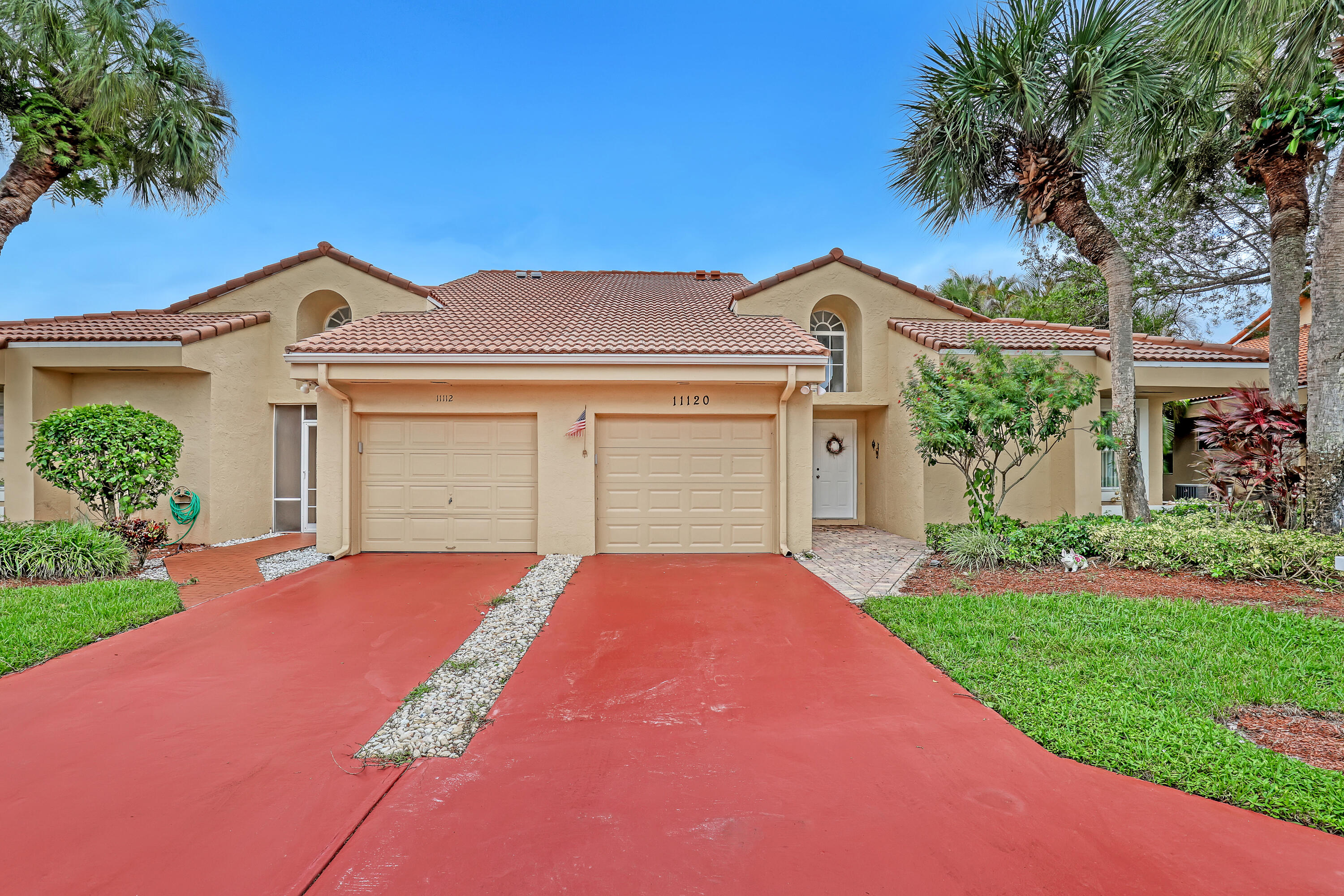 11120 Rios Road Boca Raton, FL 33498 - Photo 1 of 36 a front view of a house with a yard and garage