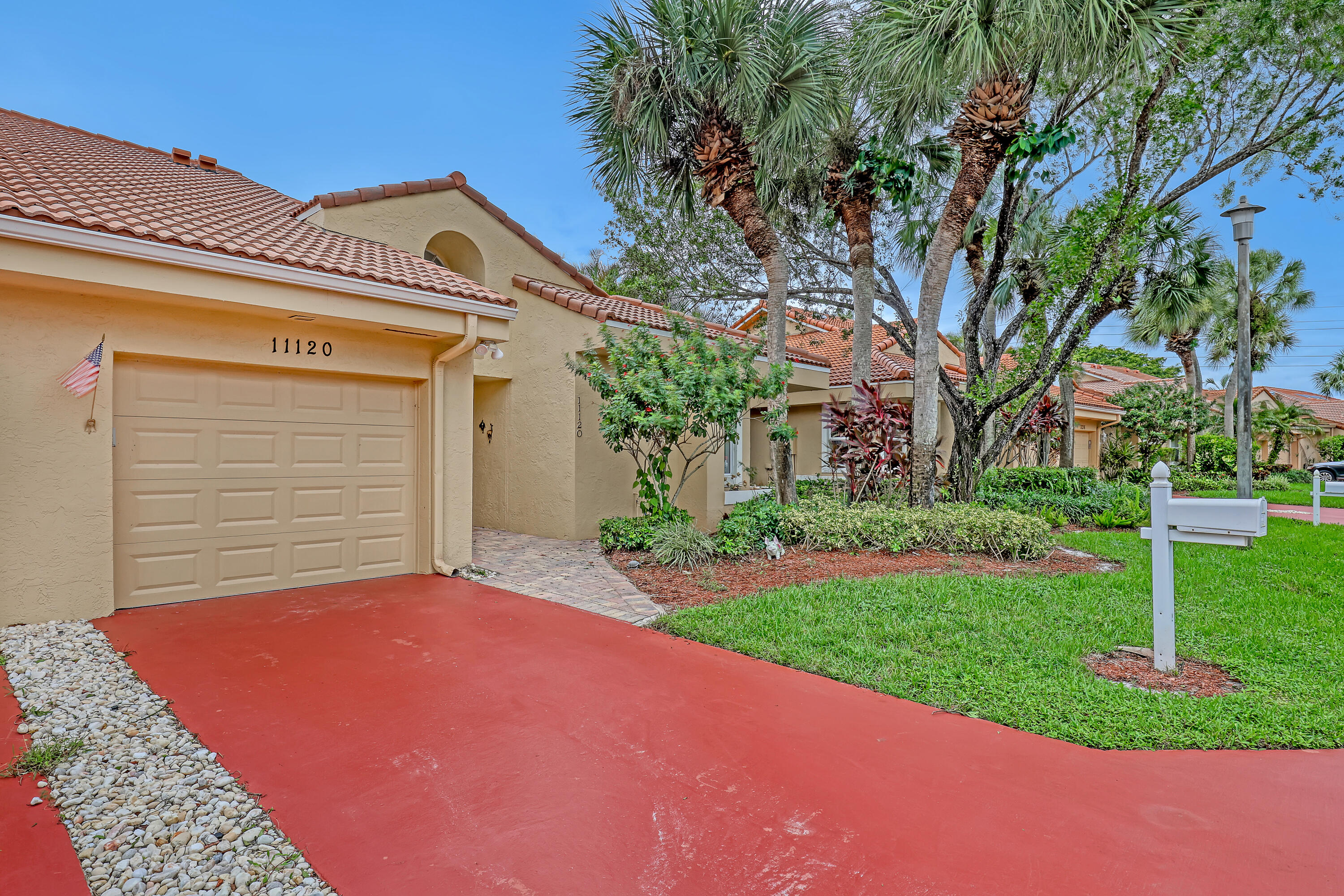 11120 Rios Road Boca Raton, FL 33498 - Photo 2 of 36 a front view of a house with a yard and garage