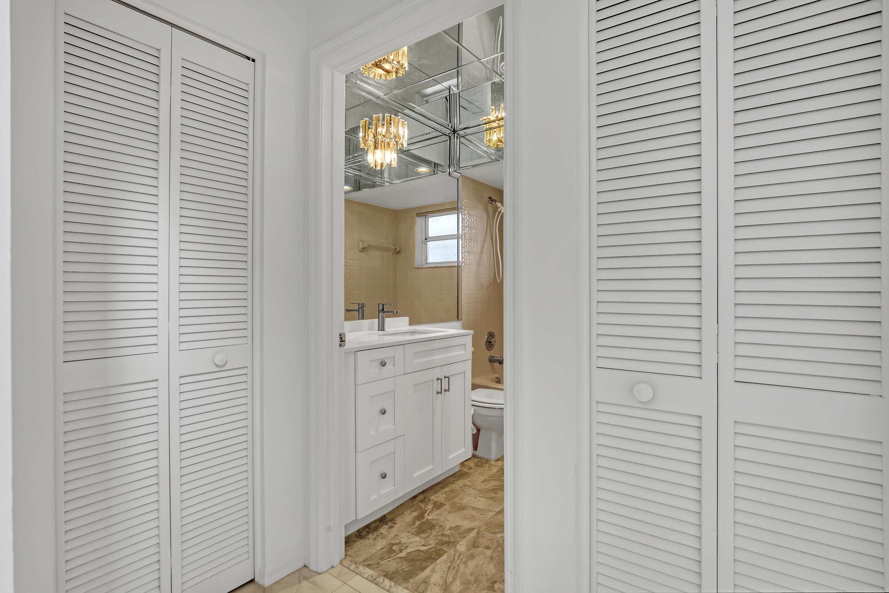 11120 Rios Road Boca Raton, FL 33498 - Photo 29 of 36 a bathroom with a sink a light fixture and a mirror