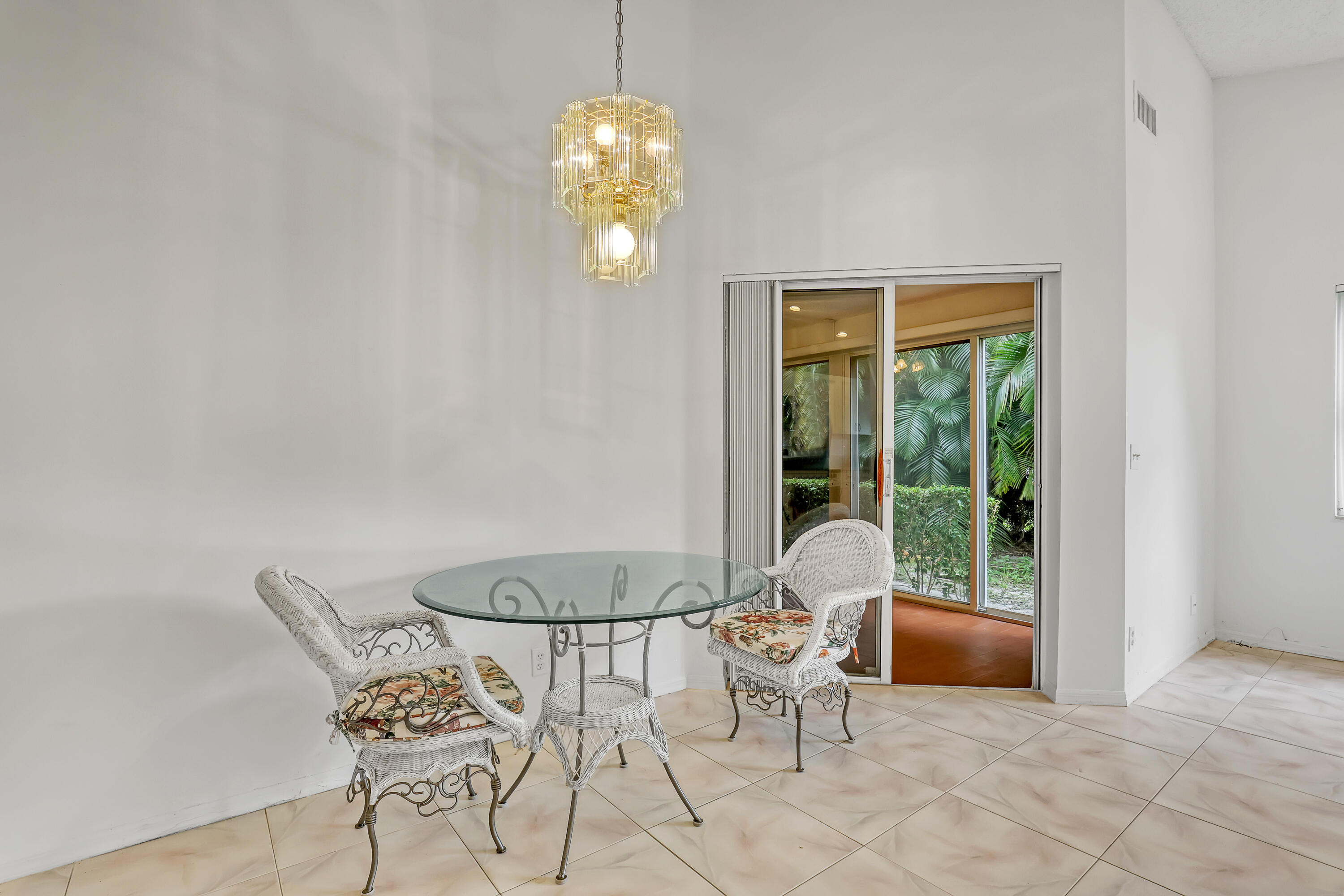 11120 Rios Road Boca Raton, FL 33498 - Photo 10 of 36 a view of a dining room with furniture wooden floor and a chandelier