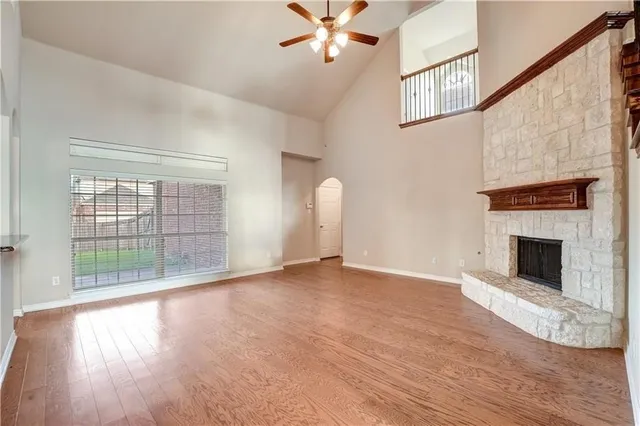a view of empty room with wooden floor and fireplace