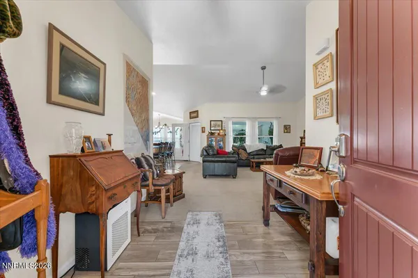 a kitchen with stainless steel appliances kitchen island granite countertop a refrigerator a stove a sink a dining table and chairs with wooden floor