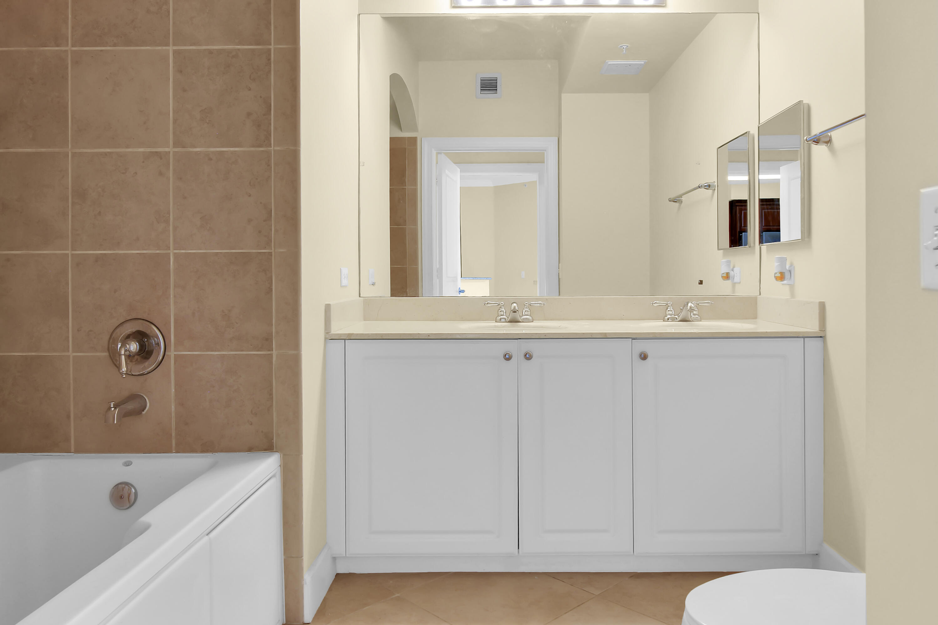 1690 Renaissance Commons Boulevard Boynton Beach, FL 33426 - Photo 5 of 22 a bathroom with a tub a sink and mirror