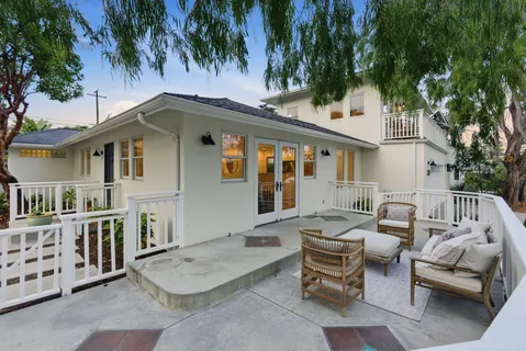 a backyard of a house with barbeque oven table and chairs