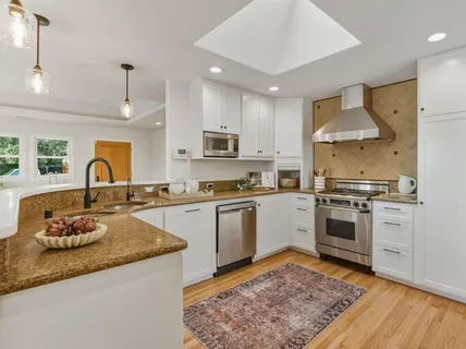 a kitchen with granite countertop stainless steel appliances and wooden cabinets