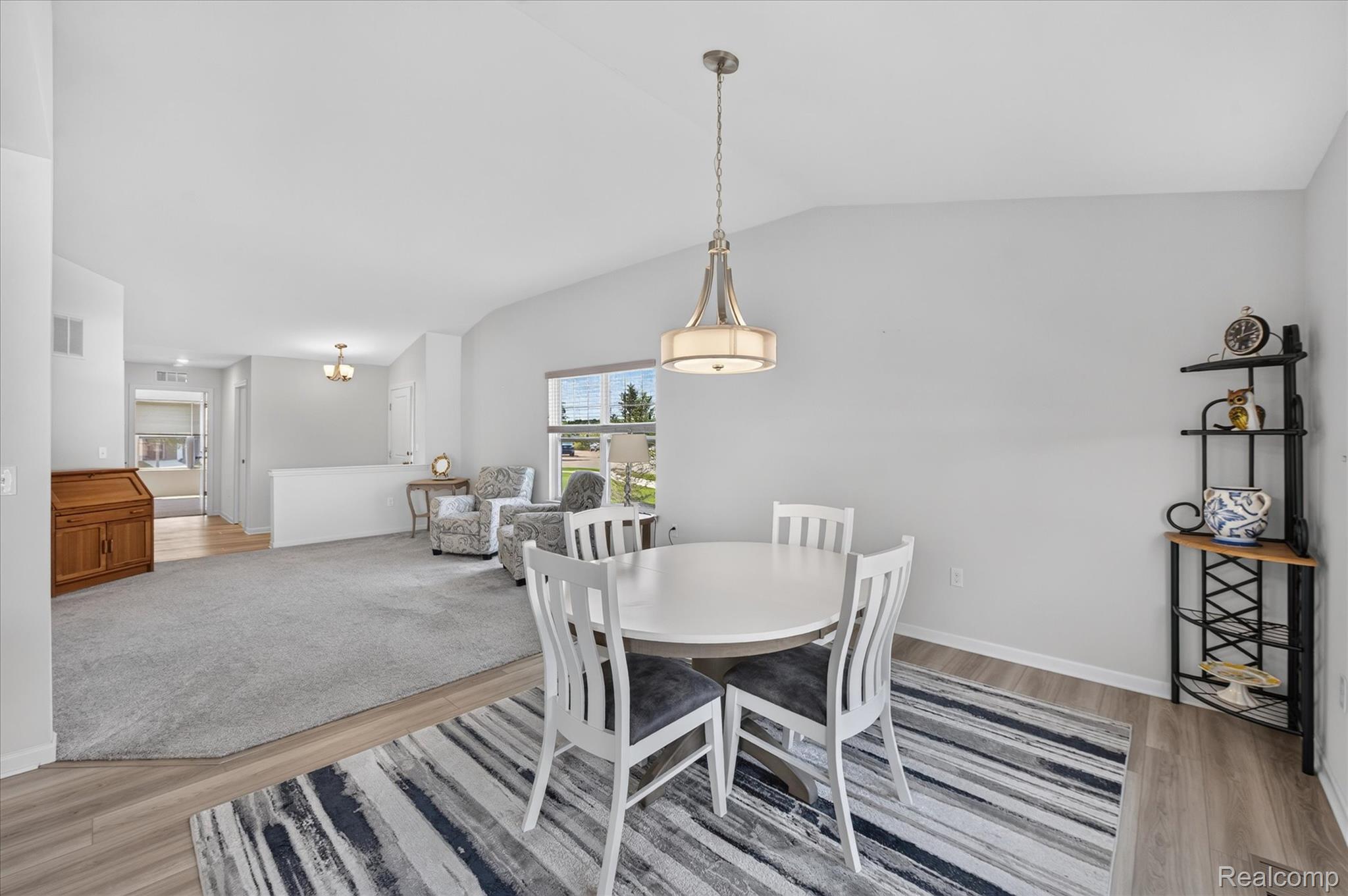 Open-concept living and dining space with vaulted ceiling.
