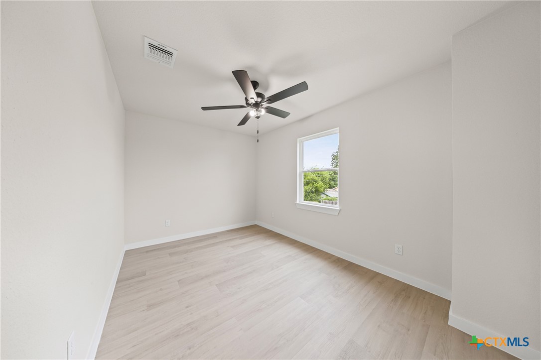 1204 Martin Luther King Jr Lane, Unit B Temple, TX 76504 - Photo 12 of 22 an empty room with window and ceiling fan