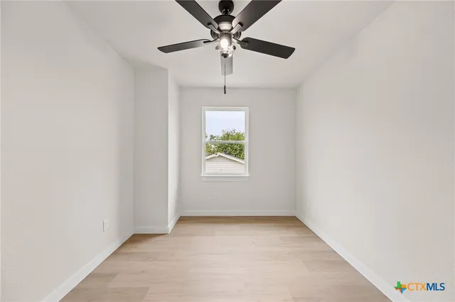 an empty room with a ceiling fan and a ceiling fan