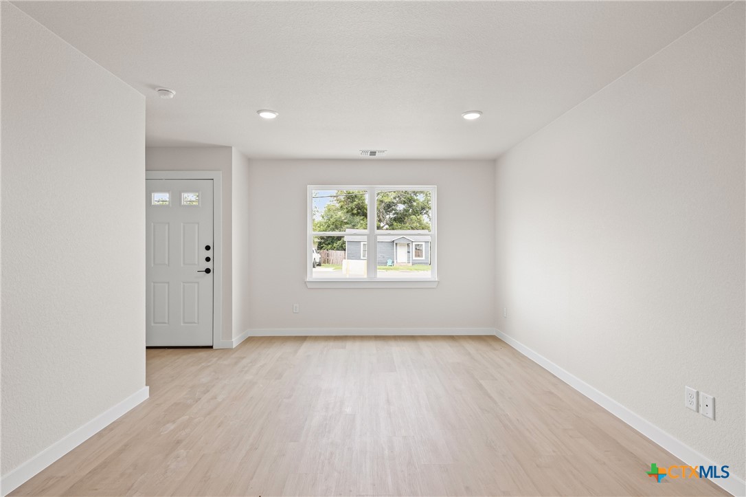 1204 Martin Luther King Jr Lane, Unit B Temple, TX 76504 - Photo 5 of 22 an empty room with wooden floor and windows