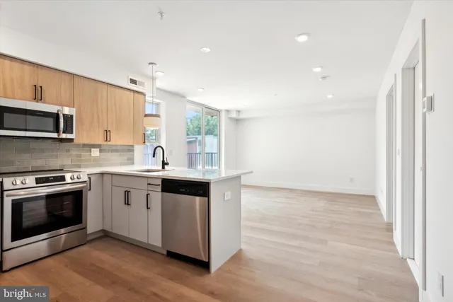 a kitchen with granite countertop a stove a sink and a microwave