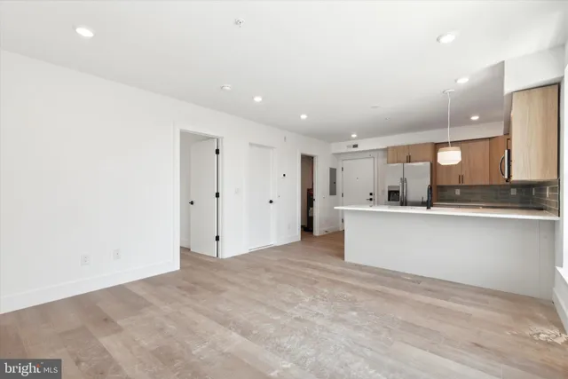 a view of kitchen with kitchen island white cabinets and stainless steel appliances