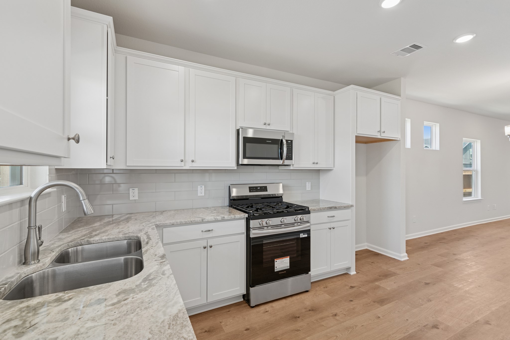 9793 Enclave Ridge Road Willis, TX 77318 - Photo 20 of 20 a kitchen with white cabinets sink and stainless steel appliances