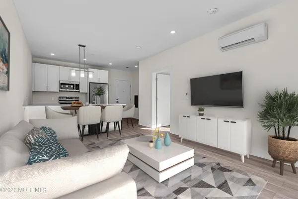 a living room with furniture a flat screen tv and kitchen view