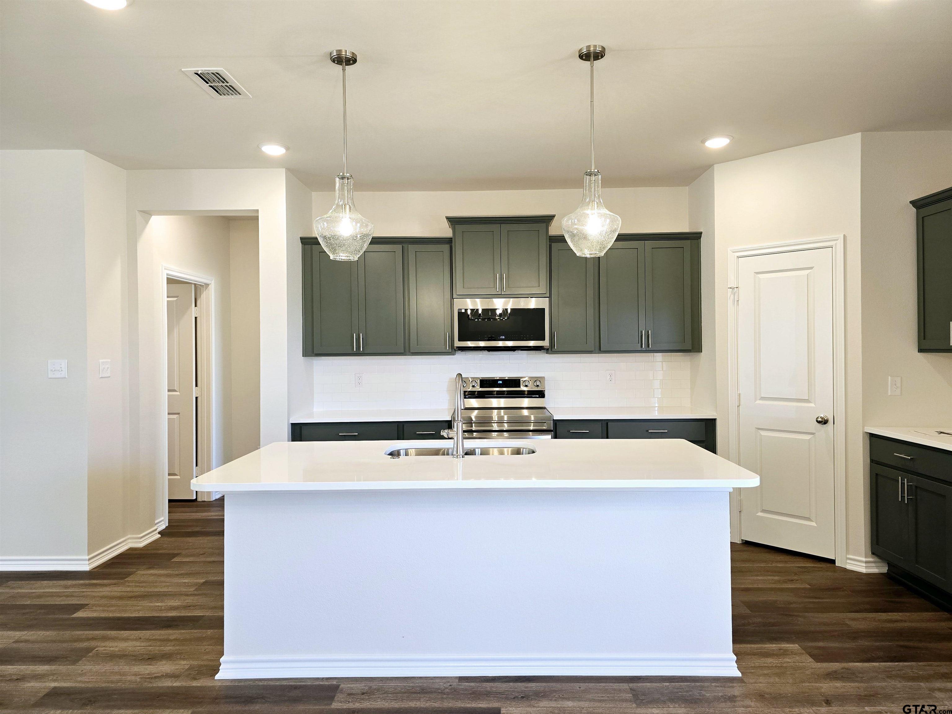 602 Kidd Drive Chandler, TX 75758 - Photo 6 of 22 a large kitchen with kitchen island a stove a sink a center island and wooden floor