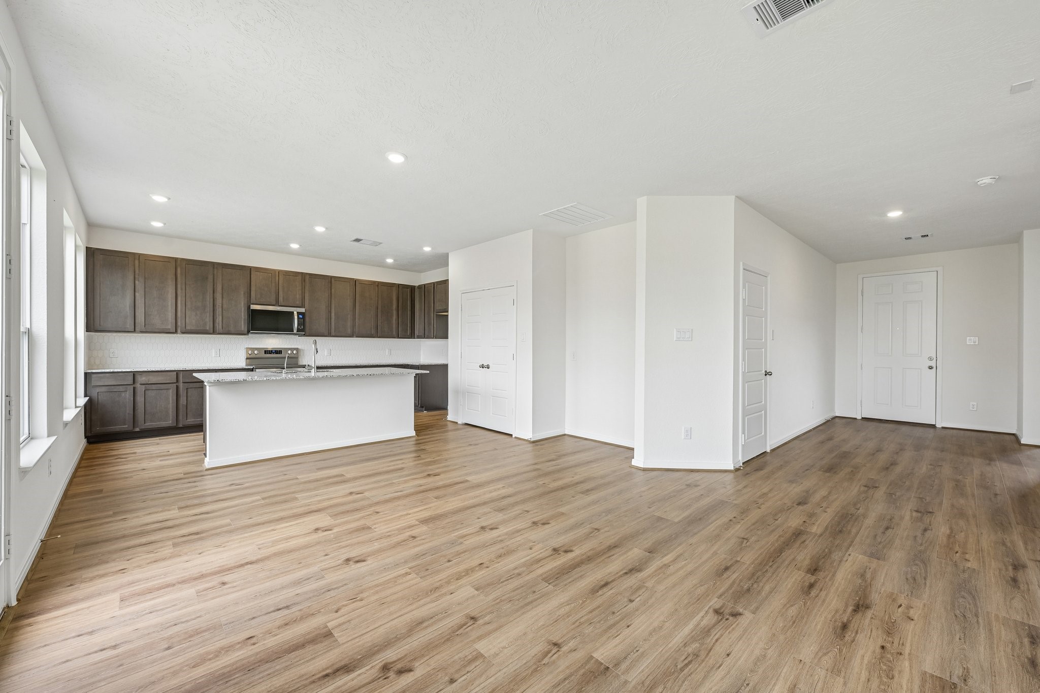 2503 Spruce Hl Road Beasley, TX 77417 - Photo 9 of 25 Create lasting memories around the table with family and friends in this inviting dining room! It showcases high ceilings, large window, access door to the backyard, vinyl plank flooring, and recessed lighting for a warm and welcoming atmosphere.