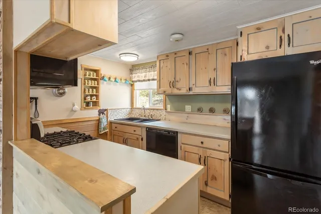 a kitchen with a refrigerator a stove a sink and a cabinets with wooden floor