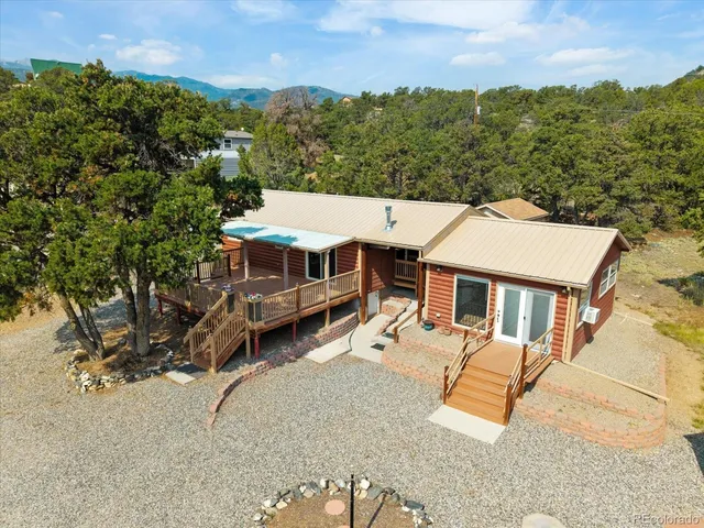 an aerial view of a house with swimming pool and large trees
