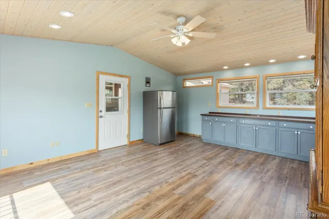 a large kitchen with stainless steel appliances granite countertop a lot of cabinets and wooden floor