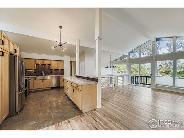 a kitchen with stainless steel appliances kitchen island wooden floors stove and white cabinets