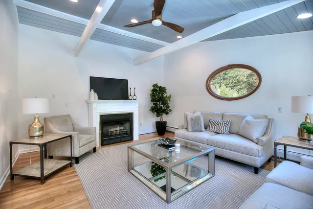 a living room with furniture a fireplace and a flat screen tv
