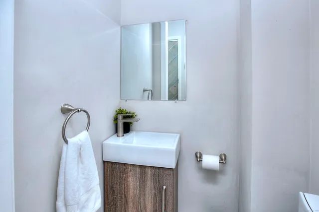 a bathroom with a sink a toilet and mirror