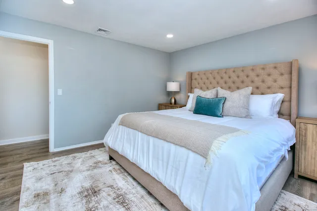 a bedroom with a bed and wooden floor