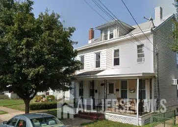 a view of a white house with large windows and a large tree